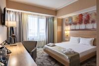 a hotel room with a bed and a desk at Renion Park Hotel in Almaty