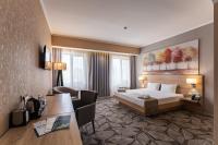 a hotel room with a bed and a desk at Renion Park Hotel in Almaty
