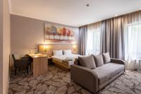 a hotel room with a bed and a couch at Renion Park Hotel in Almaty