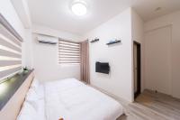 a white bedroom with a bed and a window at 向晴民宿 花蓮市包棟民宿 in Hualien City