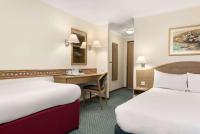 Una habitación de hotel con dos camas y un escritorio. en Days Inn by Wyndham Donington, en Castle Donington