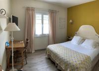 a bedroom with a bed and a desk and a window at The Originals Boutique, Hôtel du Parc, Cavaillon (Inter-Hotel) in Cavaillon