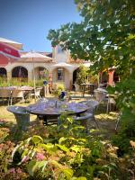 un patio avec une table et des chaises devant une maison dans l'établissement Domaine de la Terrasse, à Carbonne