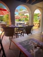 un patio extérieur avec tables, chaises et parasols dans l'établissement Domaine de la Terrasse, à Carbonne