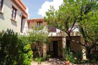Una casa con balcón y árboles delante. en Hotel Boutique La Posada, en Sucre