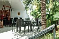 a dining room with a table and chairs and a palm tree at Island Zephyr in Baa Atoll