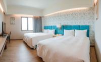 two beds in a hotel room with blue walls at Jia Hsin Garden Hotel in Tainan