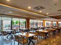 a restaurant with tables and chairs and windows at Porto Amore Club Hotel in Alanya