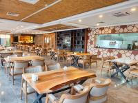 a dining room with wooden tables and chairs at Porto Amore Club Hotel in Alanya