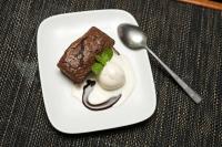 Un plato blanco con un postre sobre una mesa con una cuchara. en Volivoli Beach Resort, en Rakiraki