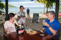 Un grupo de personas sentadas en una mesa con una pizza. en Volivoli Beach Resort, en Rakiraki