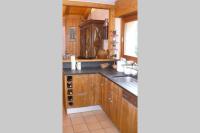 a kitchen with wooden cabinets and a sink at Le chalet de Julbert in Combloux
