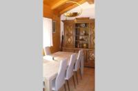 a dining room with a table and white chairs at Le chalet de Julbert in Combloux