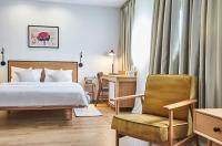 a hotel room with a bed and a chair at Urban Park Hotels in Tbilisi City