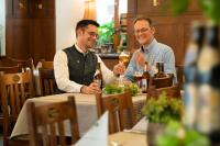 two men sitting at a table drinking wine at Sperber Bräu - 3-Sterne-Superior Hotel mit Gasthof und eigener Brauerei - kein Ruhetag in Sulzbach-Rosenberg