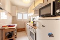 a kitchen with a white refrigerator with a microwave at Gwenhen - Appartement vue mer in Courseulles-sur-Mer