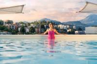 Una mujer parada en el agua de una piscina en Hotel Admiral Lugano, en Lugano