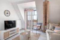 a living room with a tv and a couch at Charmant appartement sur le remblai de Pleneuf Val Andre in Pléneuf-Val-André