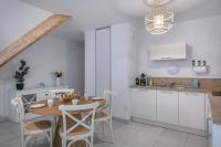 a kitchen and dining room with a table and chairs at Charmant appartement sur le remblai de Pleneuf Val Andre in Pléneuf-Val-André