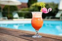 a drink sitting on a table next to a pool at Résidence de Diane - Toulouse in Toulouse