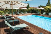 a swimming pool with chairs and umbrellas on a deck at Résidence de Diane - Toulouse in Toulouse