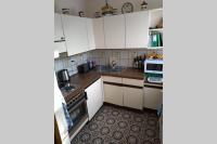a small kitchen with white cabinets and a sink at Evita Wörthersee in Krumpendorf am Wörthersee