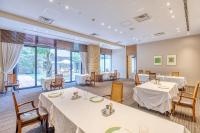 a dining room with tables and chairs and large windows at Hotel Grand Fuji in Fuji