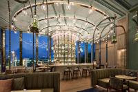 a restaurant with a bar with a view of the city at Four Seasons Hotel Hong Kong in Hong Kong