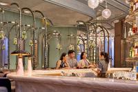 a group of people sitting at a bar at Four Seasons Hotel Hong Kong in Hong Kong