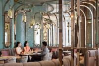 a group of people sitting at tables in a restaurant at Four Seasons Hotel Hong Kong in Hong Kong