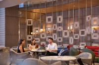 a group of people sitting at tables in a restaurant at Four Seasons Hotel Hong Kong in Hong Kong
