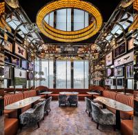 a restaurant with tables and chairs and a chandelier at Four Seasons Hotel Hong Kong in Hong Kong