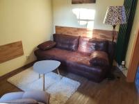 a living room with a brown leather couch at Ferienhaus am Wasserturm Angermünde in Angermünde