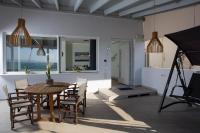 a dining room with a table and chairs and a camera at Kyma Seafront Suite by Estia in Kokkini Khanion