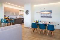 a kitchen and living room with a table and blue chairs at Kyma Seafront Suite by Estia in Kokkini Khanion