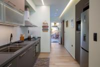 a kitchen with stainless steel appliances and a wooden floor at Kyma Seafront Suite by Estia in Kokkini Khanion