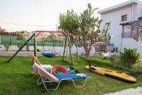a playground with a swing and a chair and kayaks at Kyma Seafront Suite by Estia in Kokkini Khanion