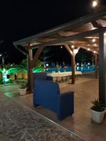 een terras 's nachts met een blauwe bank bij Hotel La Playa Blanca in Santo Stefano di Camastra
