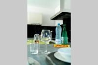 a table with two glasses and bottles of wine at La Villetta G Blotzheim - Appartement de Standing in Blotzheim