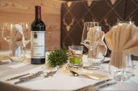 uma garrafa de vinho sentada numa mesa com copos em Hotel La Perla em Andalo