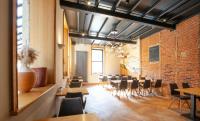 a dining room with tables and chairs and a brick wall at Hotel The Lodge Heverlee in Leuven