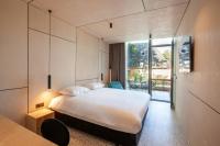 a bedroom with a large bed and a large window at Hotel The Lodge Heverlee in Leuven