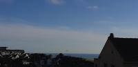 a city with houses and the ocean in the background at Entre ciel et mer, Maison neuve vue mer proche de la plage in Équihen-Plage