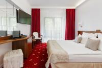 a hotel room with a bed and a desk and red carpet at Manor Ski Hotel in Predeal