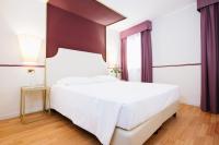 a bedroom with a large white bed and a window at Hotel Do Pozzi in Venice