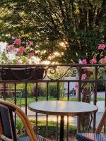 a table and chairs on a porch with a view of a garden at Hôtel Restaurant Villa Riva in Veyrier-du-Lac