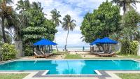 una piscina con sillas y sombrillas junto a la playa en Parangi Weligama Bay - Thema Collection, en Weligama
