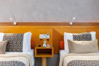 a hotel room with two beds and a table at Hotel Santorini in Vila Velha