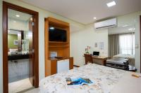 a hotel room with a bed and a bathroom at Hotel Santorini in Vila Velha