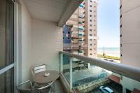 a balcony with a table and a view of the ocean at Hotel Santorini in Vila Velha